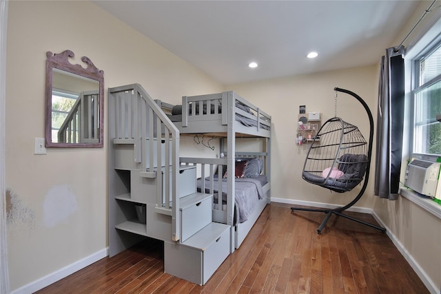 bedroom with multiple windows, baseboards, and wood finished floors