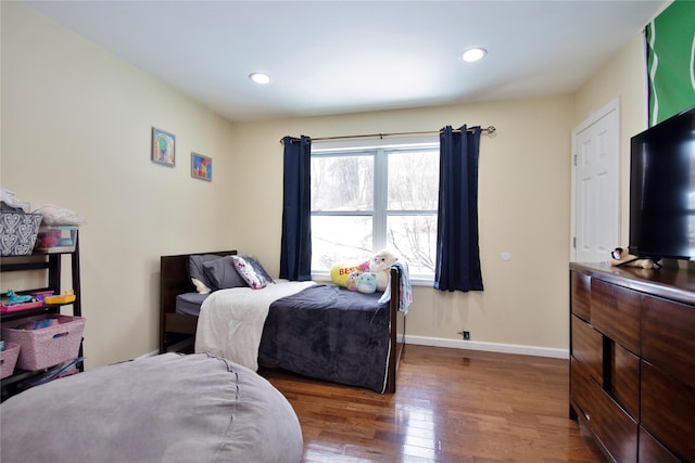 bedroom featuring baseboards, wood finished floors, and recessed lighting