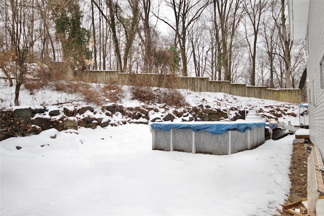 yard layered in snow featuring a covered pool and fence