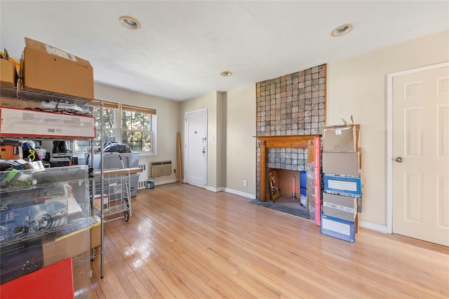 interior space with light wood-style flooring, baseboards, and a tile fireplace