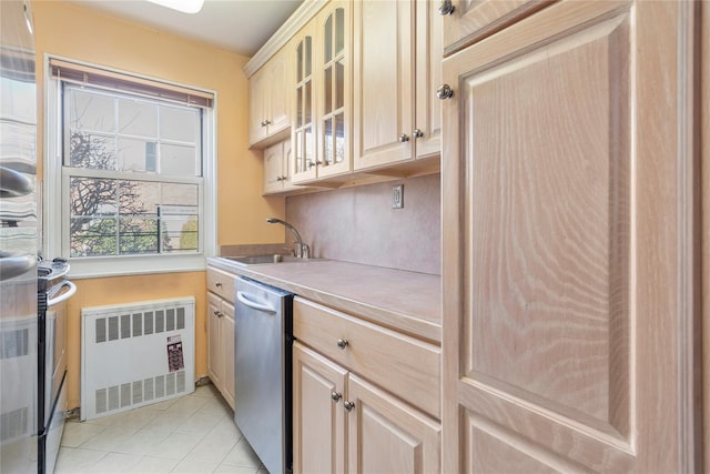 kitchen featuring radiator, light countertops, glass insert cabinets, a sink, and dishwasher