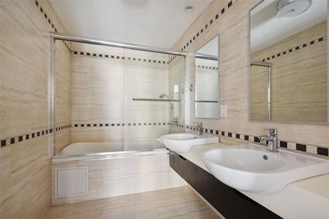 bathroom featuring tiled shower / bath, backsplash, a sink, and tile walls