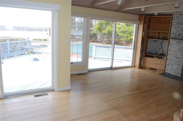 unfurnished living room featuring visible vents and wood finished floors