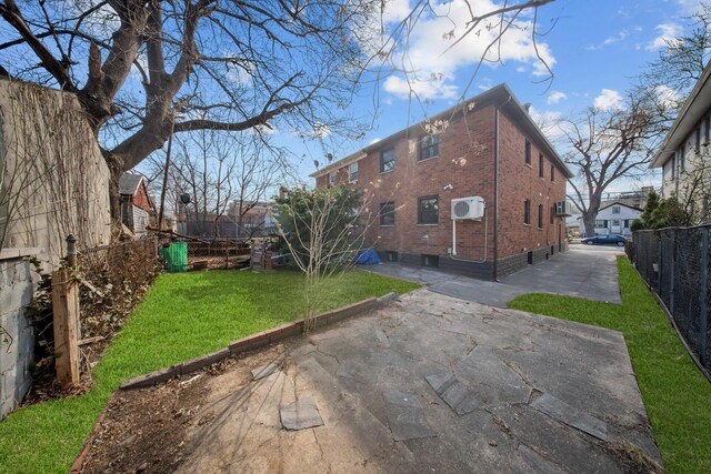 15815 77th Rd, Fresh Meadows, NY 11366 - rear view of property featuring a lawn, fence, brick siding, and a patio