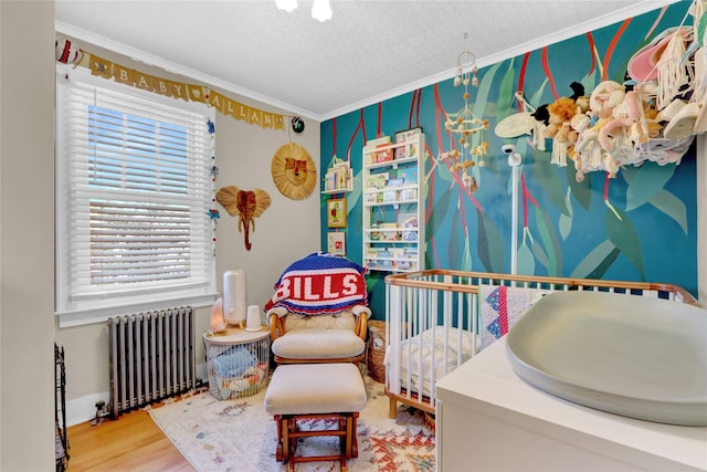 bedroom with crown molding, wood-type flooring, radiator, and a textured ceiling