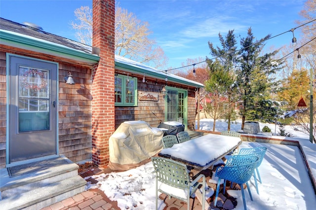 snow covered patio featuring grilling area