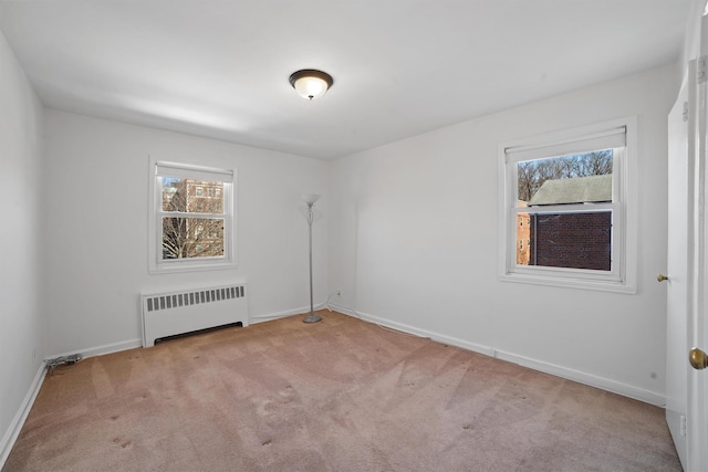 unfurnished room featuring radiator, light carpet, and baseboards