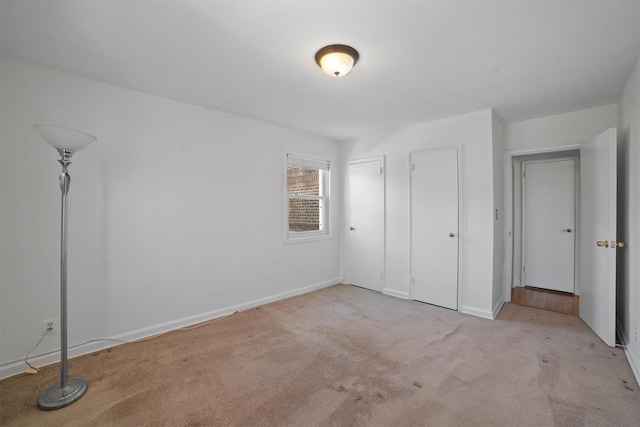 unfurnished bedroom with baseboards and light colored carpet