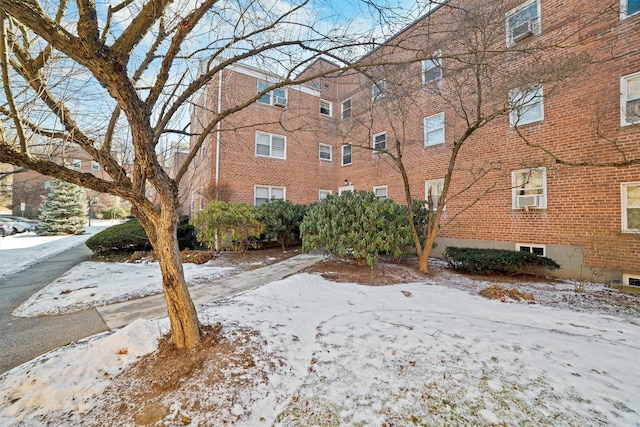 snow covered property with cooling unit