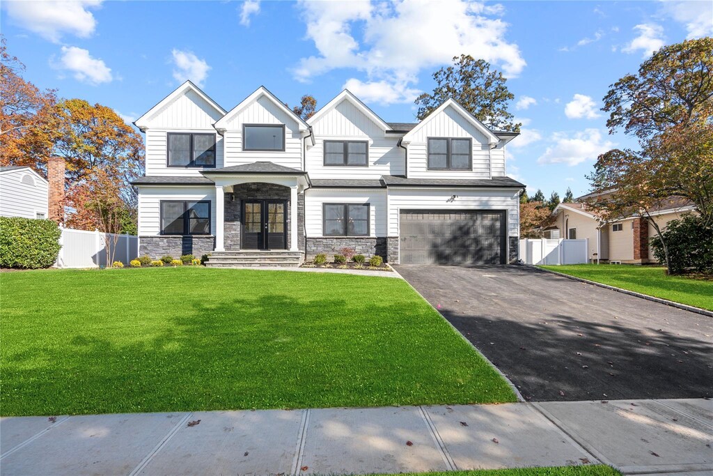 1 Newport Dr, Plainview, NY 11803 - view of front of home with a garage, a front yard, and french doors