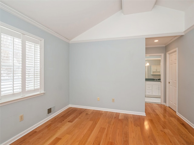 empty room with crown molding, lofted ceiling, and light hardwood / wood-style floors