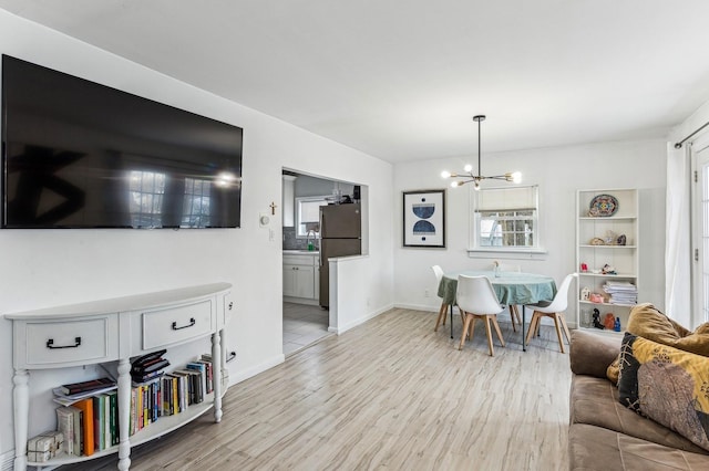 living room with light hardwood / wood-style flooring and a chandelier