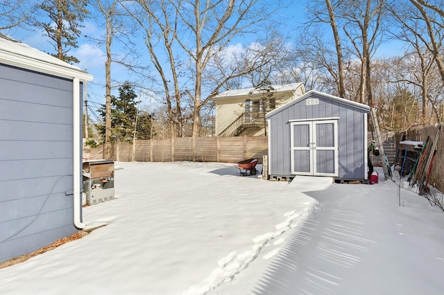 snow covered patio featuring a storage unit