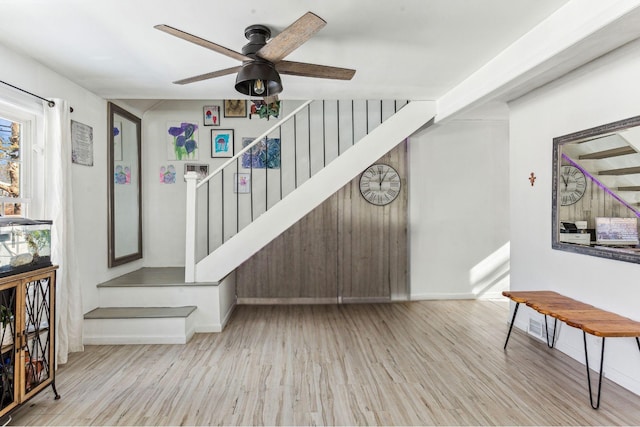 staircase featuring ceiling fan and wood finished floors