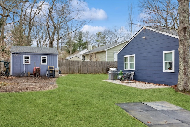 view of yard featuring an outbuilding, fence, and a shed