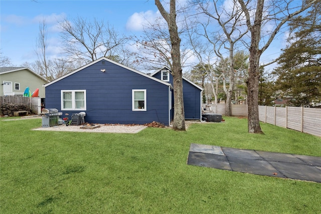 rear view of house with a lawn and fence