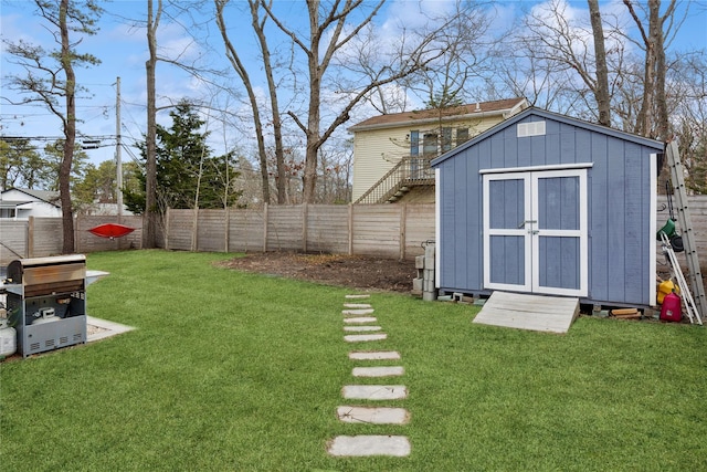 view of yard with a fenced backyard, a storage shed, and an outdoor structure