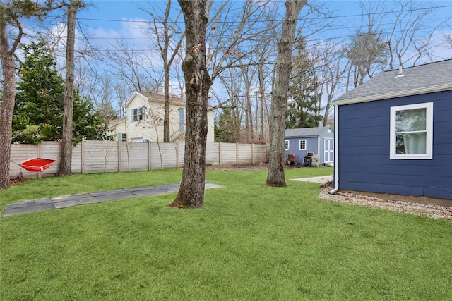 view of yard with a shed, an outdoor structure, and fence