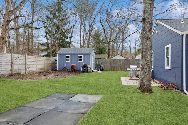 view of yard featuring a storage shed, an outdoor structure, and a fenced backyard