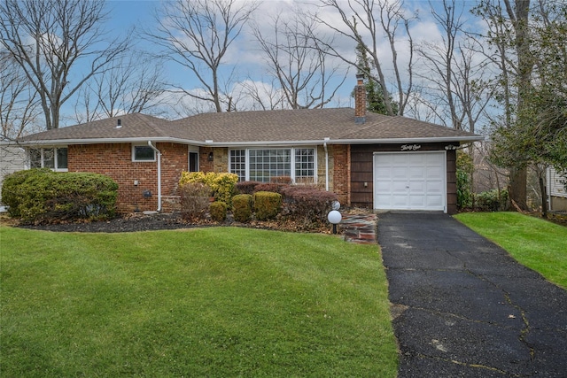 ranch-style home featuring an attached garage, brick siding, driveway, a chimney, and a front yard