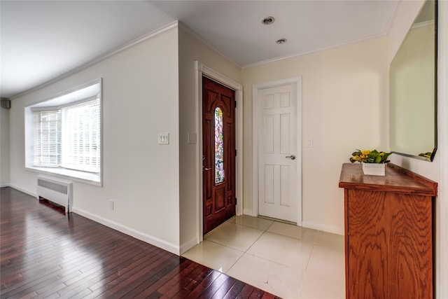 entrance foyer featuring baseboards, ornamental molding, light wood-type flooring, and radiator