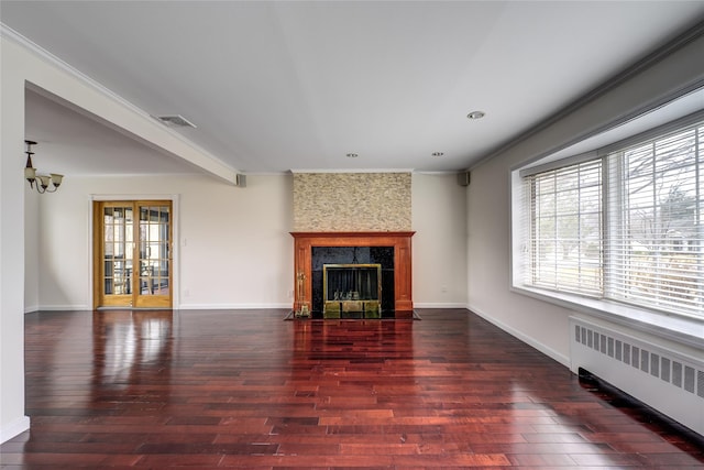 living room featuring a wealth of natural light, radiator, visible vents, and a fireplace