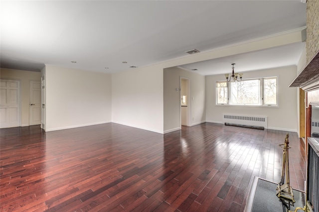 unfurnished living room featuring dark wood-style floors, a notable chandelier, radiator, visible vents, and baseboards