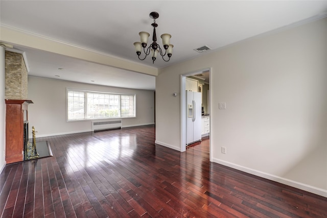 unfurnished living room with a notable chandelier, dark wood-type flooring, a fireplace, visible vents, and radiator