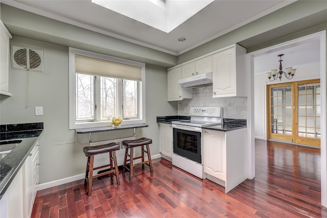 kitchen featuring dark wood finished floors, white electric range, backsplash, white cabinets, and under cabinet range hood