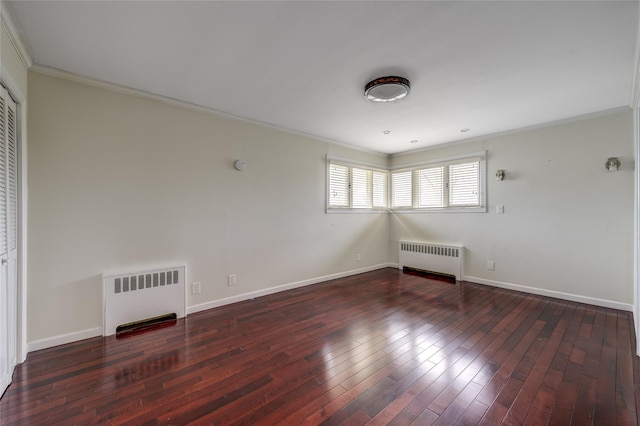 spare room with radiator heating unit, baseboards, wood-type flooring, and crown molding