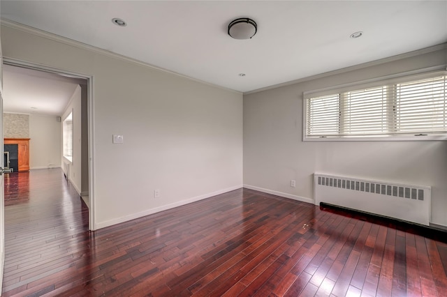 unfurnished room with hardwood / wood-style flooring, radiator heating unit, ornamental molding, and baseboards