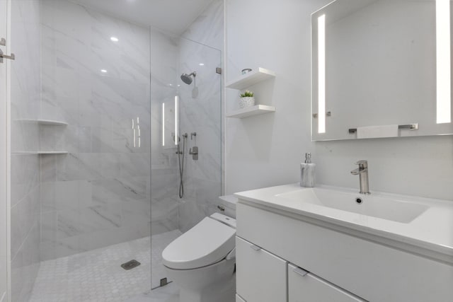 bathroom with vanity, a tile shower, and toilet