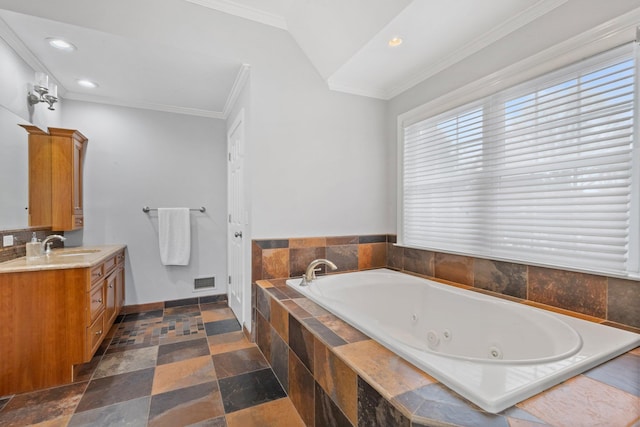 bathroom with crown molding, vaulted ceiling, a relaxing tiled tub, and vanity