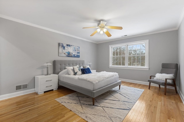 bedroom with light hardwood / wood-style flooring, ornamental molding, and ceiling fan