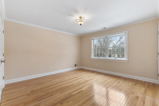 spare room featuring crown molding and light hardwood / wood-style floors