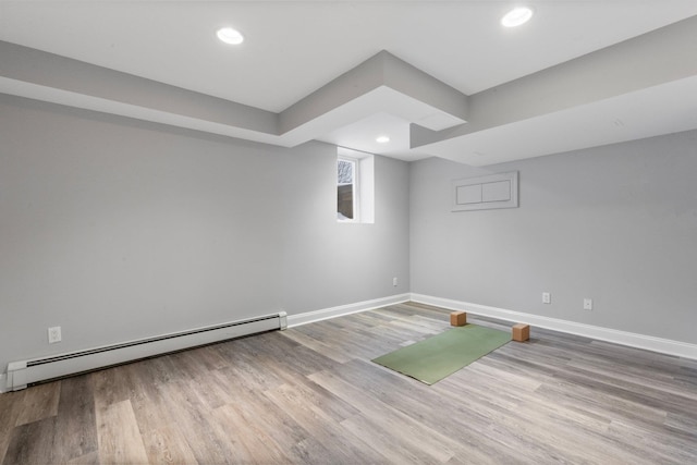 unfurnished room featuring a baseboard radiator and light hardwood / wood-style floors