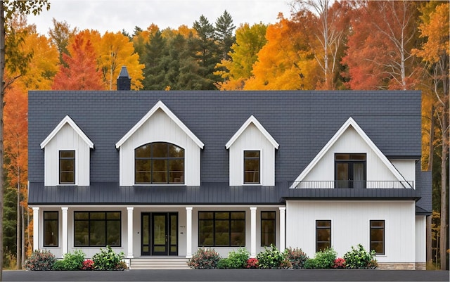 modern farmhouse style home with a balcony, a porch, metal roof, and a standing seam roof