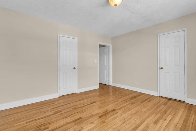 unfurnished bedroom with a textured ceiling and light hardwood / wood-style flooring