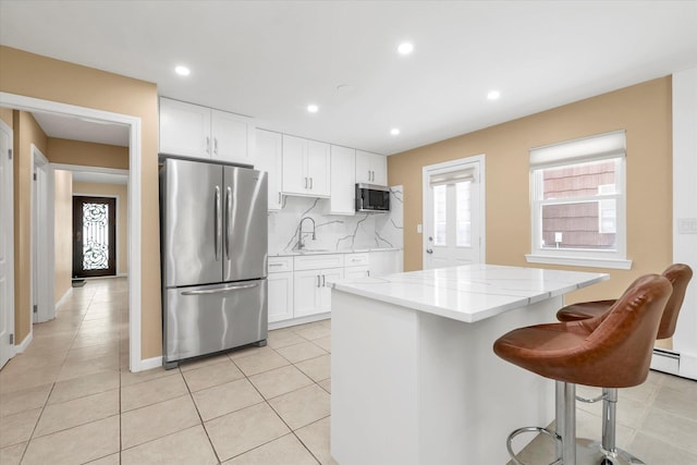 kitchen featuring backsplash, stainless steel appliances, a center island, and white cabinets