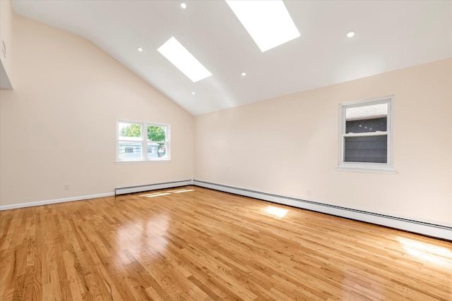 empty room with light wood-style floors, high vaulted ceiling, recessed lighting, a baseboard radiator, and a skylight