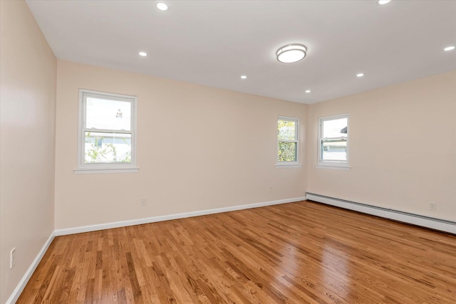 spare room featuring recessed lighting, baseboards, light wood-style flooring, and a baseboard radiator