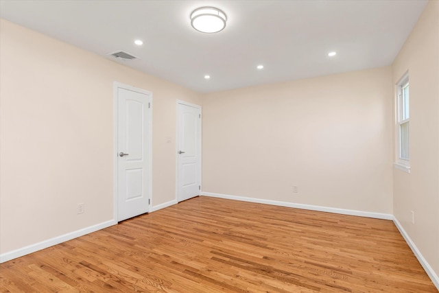 unfurnished room with recessed lighting, baseboards, light wood-type flooring, and visible vents