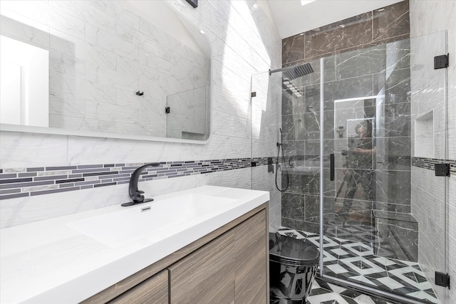 bathroom featuring vanity, a stall shower, and tile walls