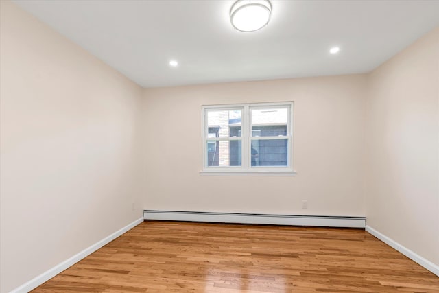 spare room featuring recessed lighting, baseboards, baseboard heating, and light wood-style floors