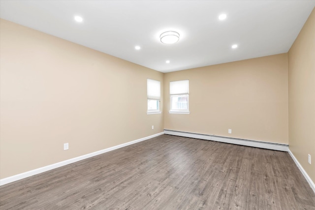 spare room with recessed lighting, baseboards, baseboard heating, and wood finished floors