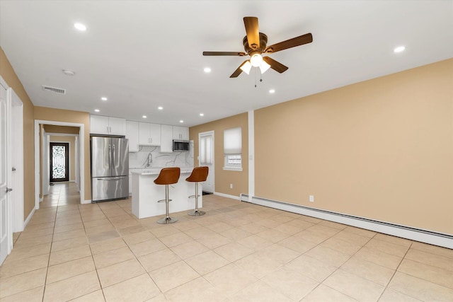 kitchen featuring a ceiling fan, visible vents, light countertops, a baseboard heating unit, and stainless steel appliances