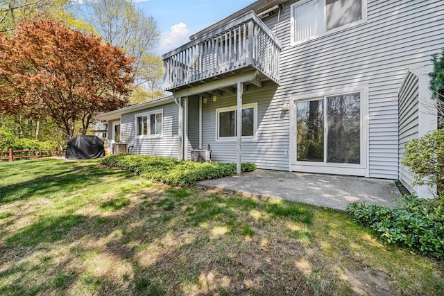 rear view of house with fence, central AC, a deck, a patio area, and a lawn