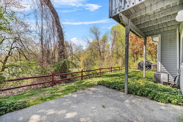 view of patio featuring a grill, fence, and cooling unit