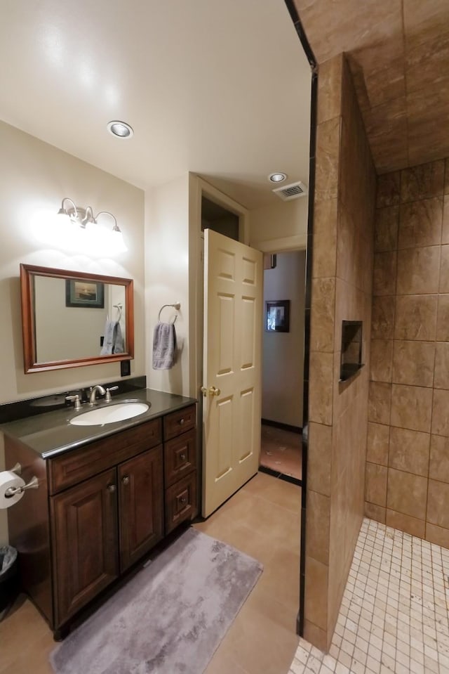 bathroom with recessed lighting, visible vents, tiled shower, and vanity