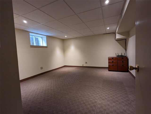 basement with a drop ceiling, carpet, and baseboards